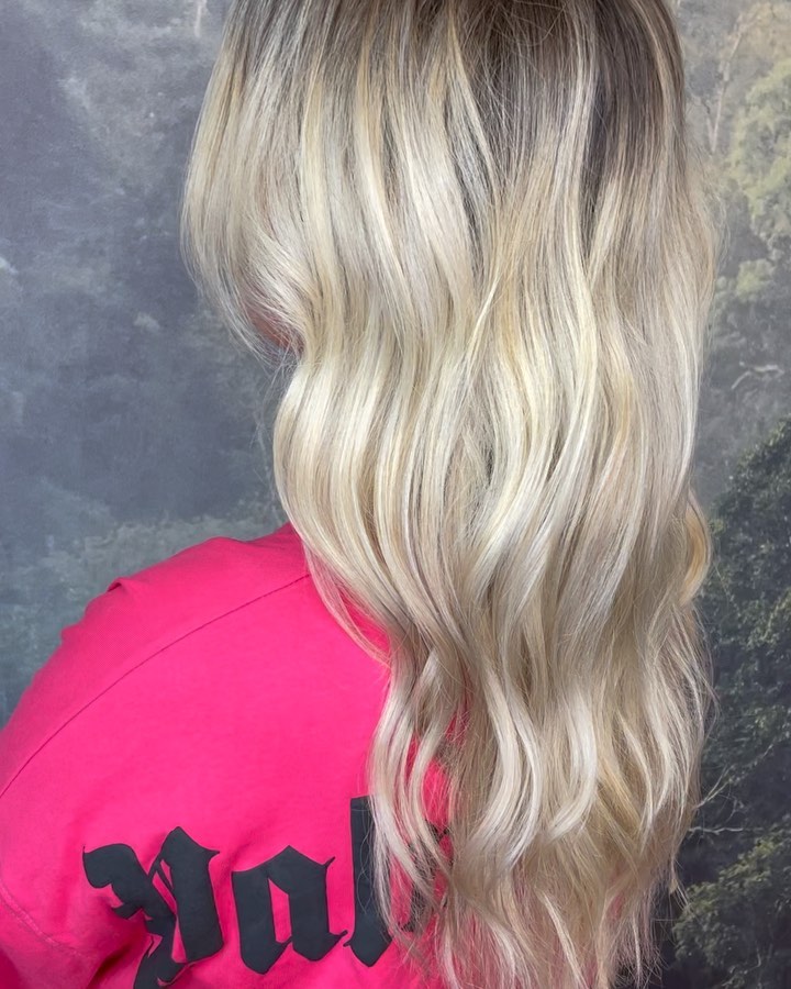 Cool blonde balayage with soft beach waves and dimensional colour