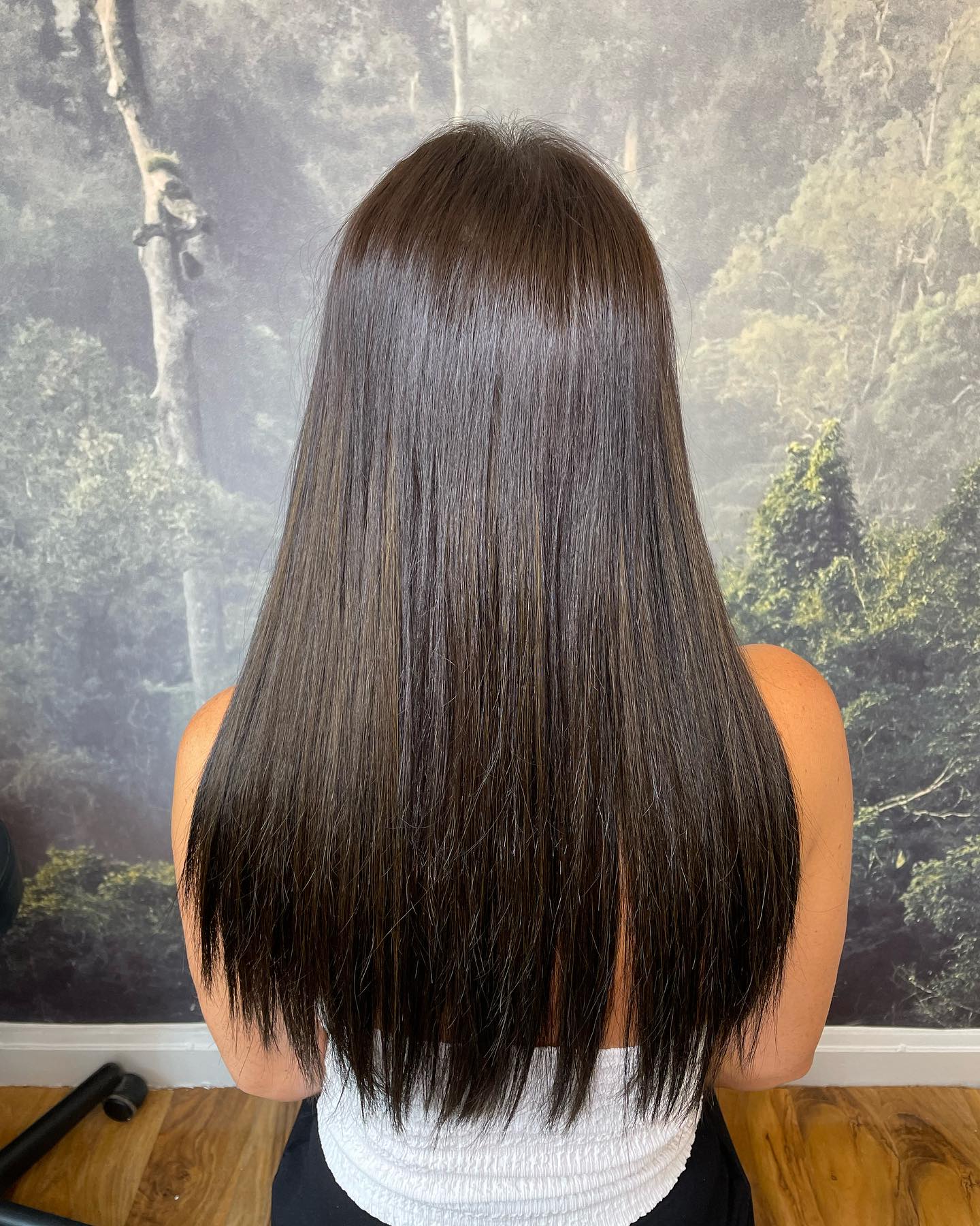 Glossy dark brunette hair with mirror-like shine and smooth finish