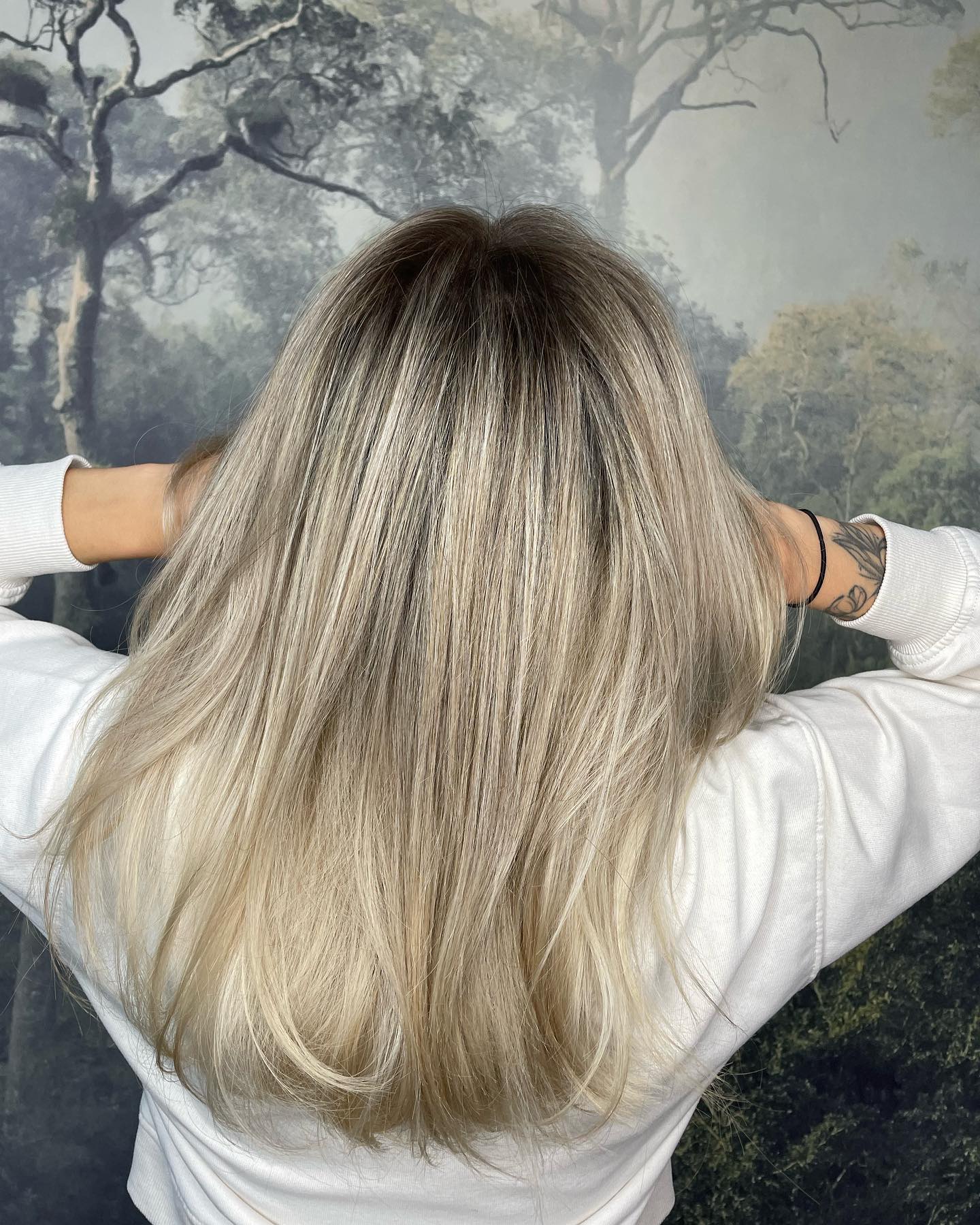 Platinum blonde balayage with lived-in root and natural texture