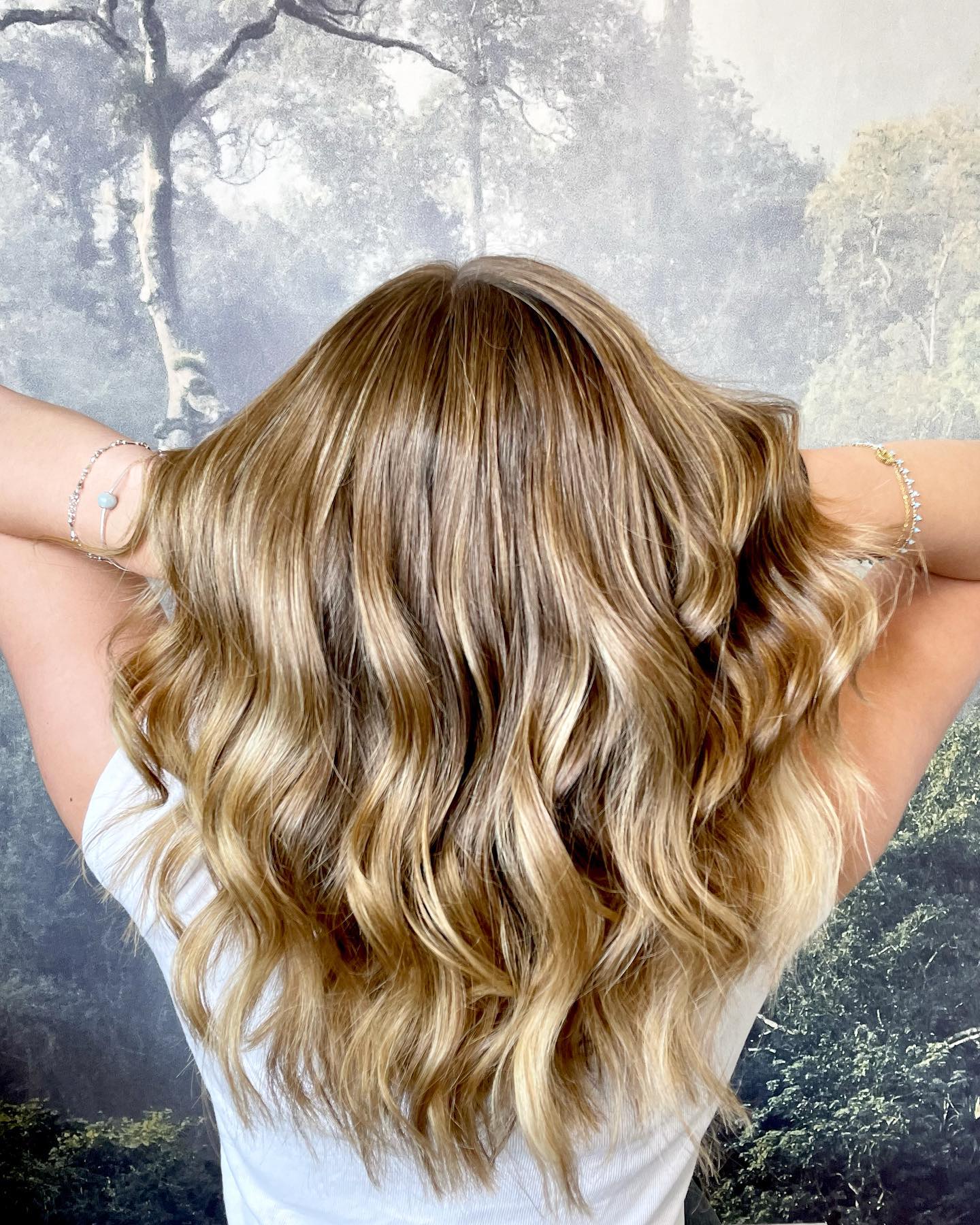 Dimensional blonde balayage with soft waves and lived-in root blend