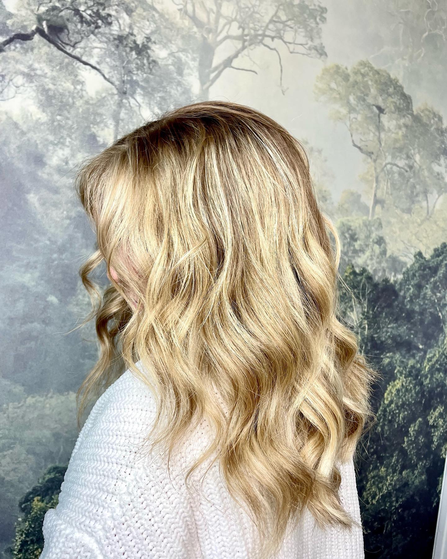 Soft golden blonde balayage with loose waves and face-framing brightness