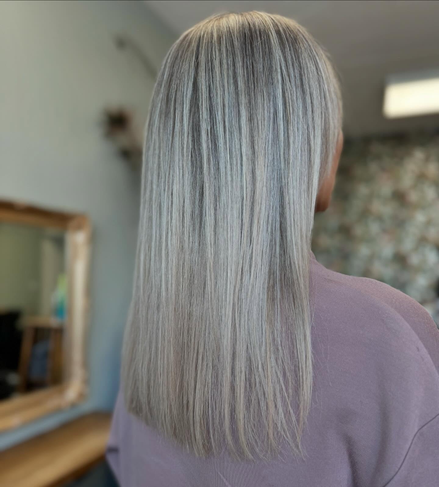 Cool-toned icy blonde hair with sleek straight finish and high shine