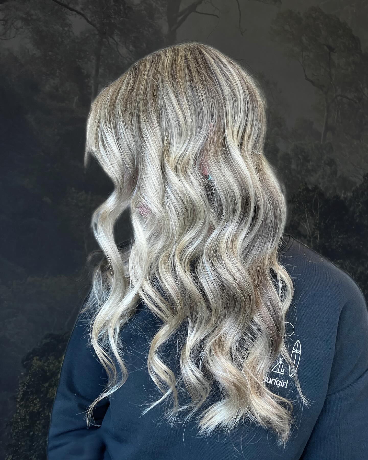 Platinum blonde balayage with seamless blend and soft flowing curls