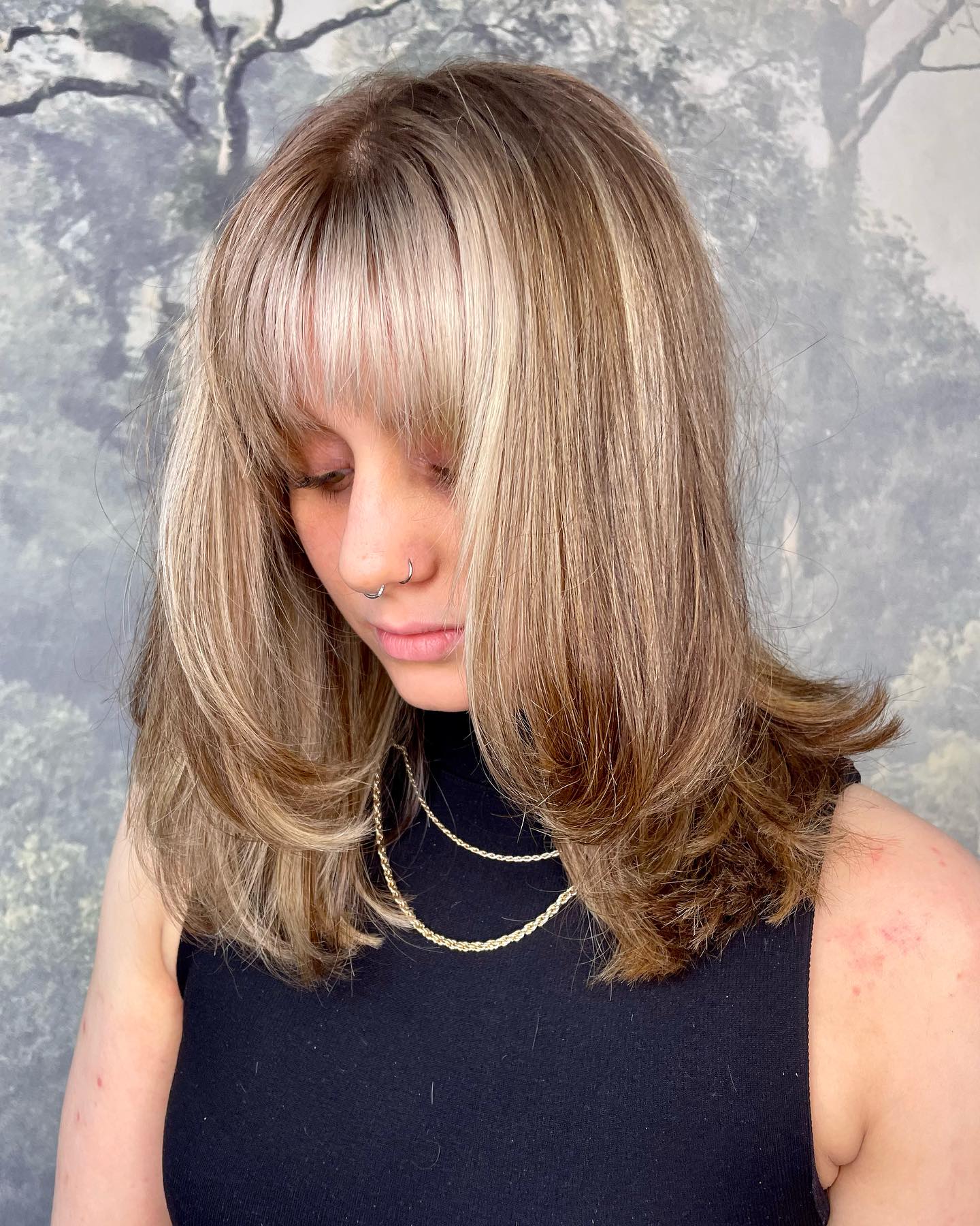 Layered blonde hair with curtain fringe and soft face-framing shape