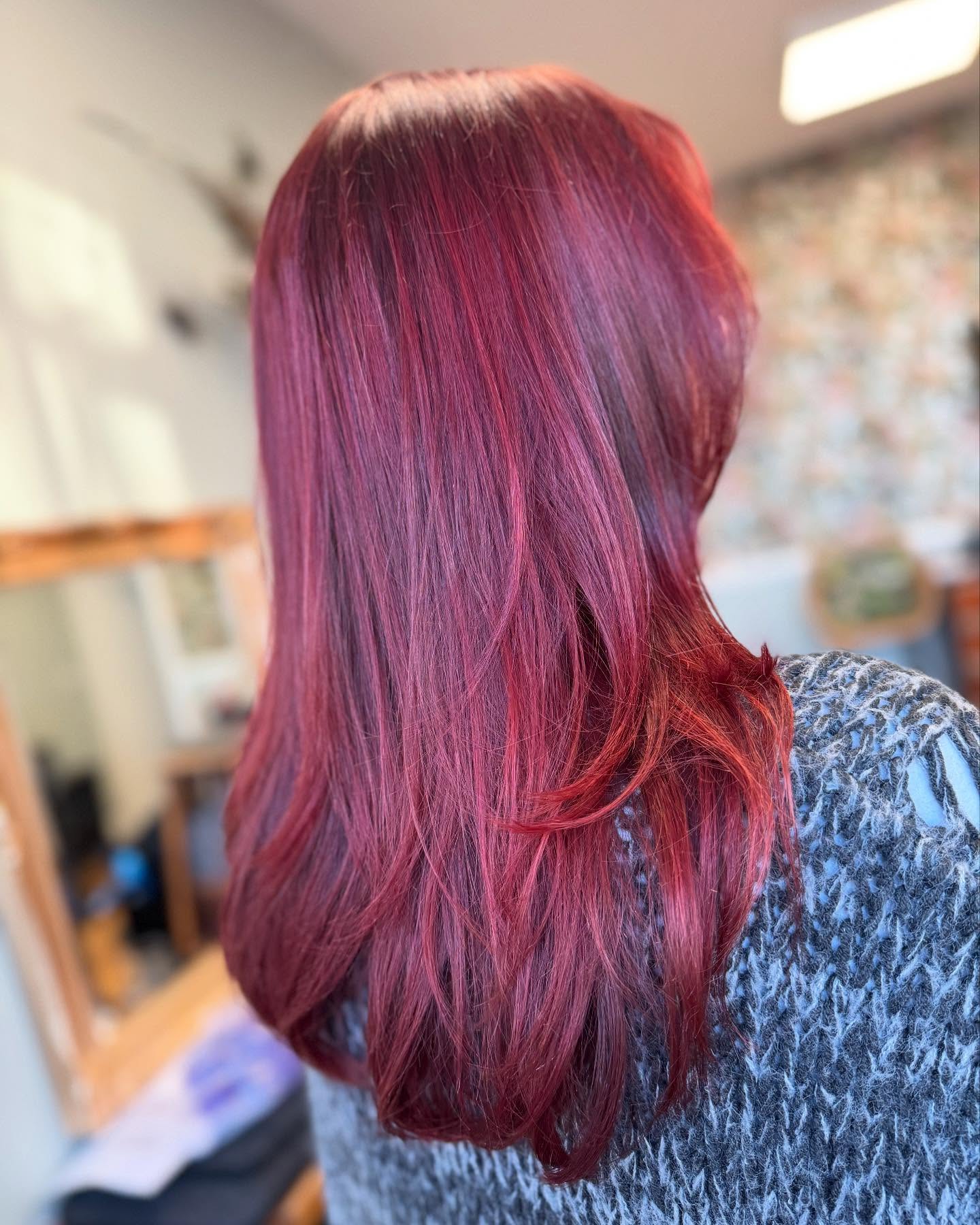 Deep red fashion hair colour with glossy finish and soft layers