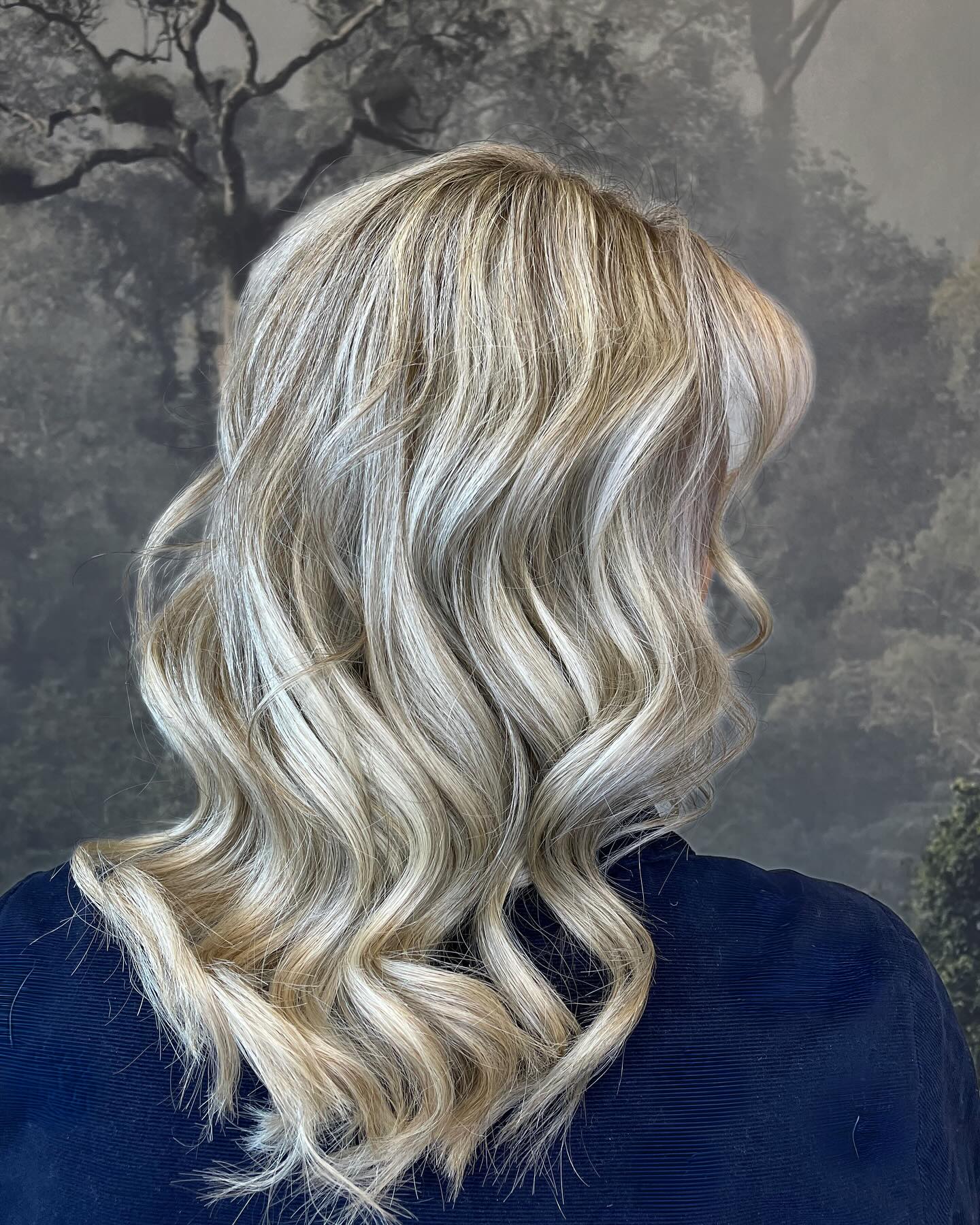 Cool blonde balayage with soft waves and natural root melt