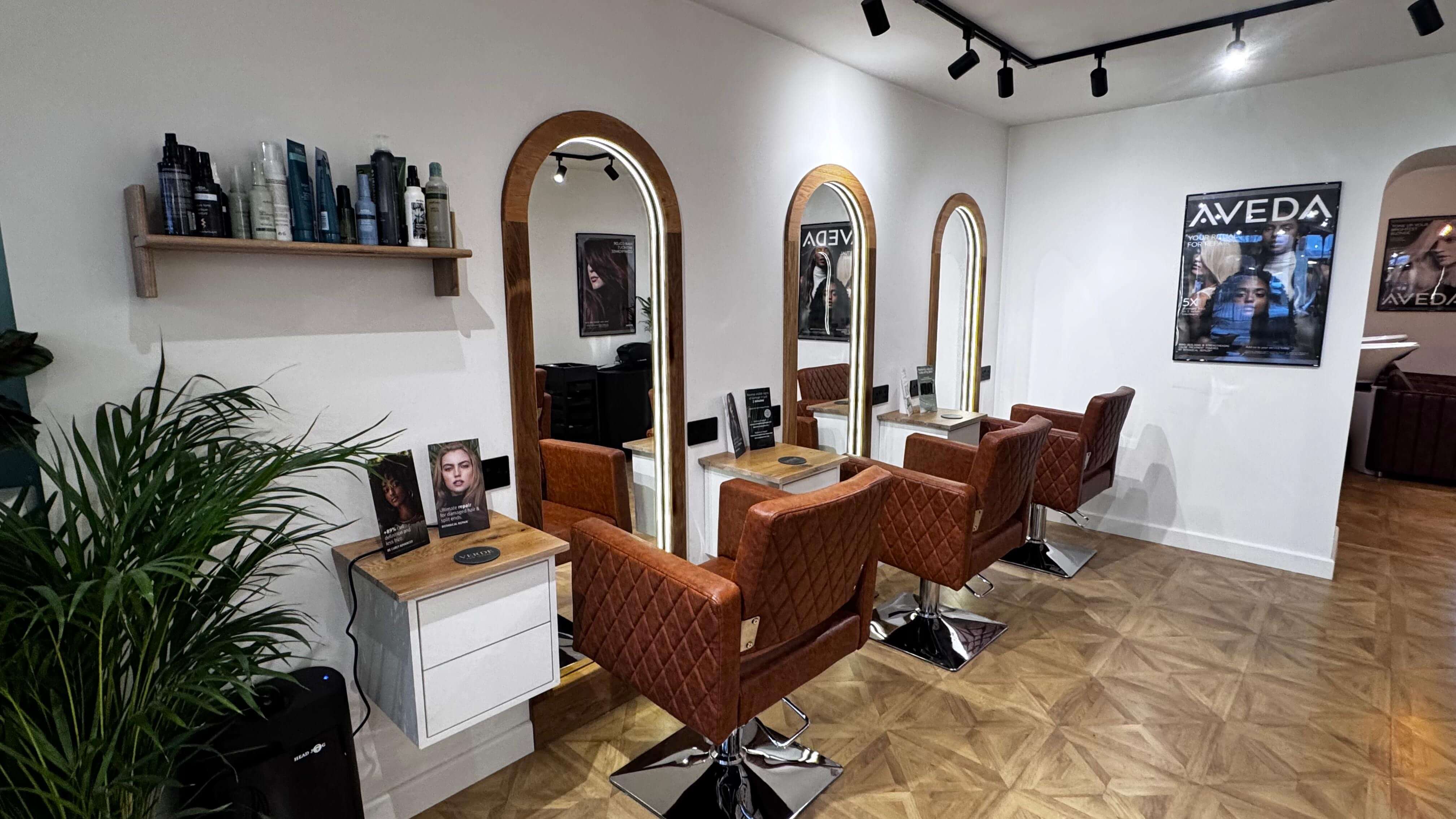 Styling stations inside Verde Hair Lounge with illuminated mirrors and premium salon chairs